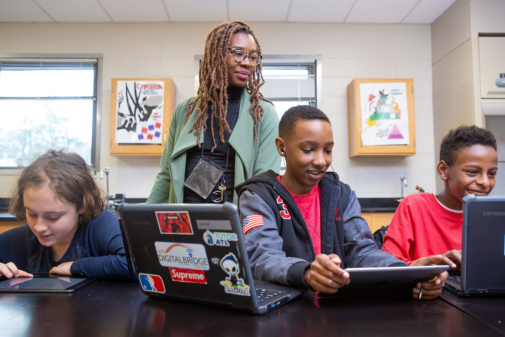 A teacher helps students during a coding lesson at Sutton Middle School.