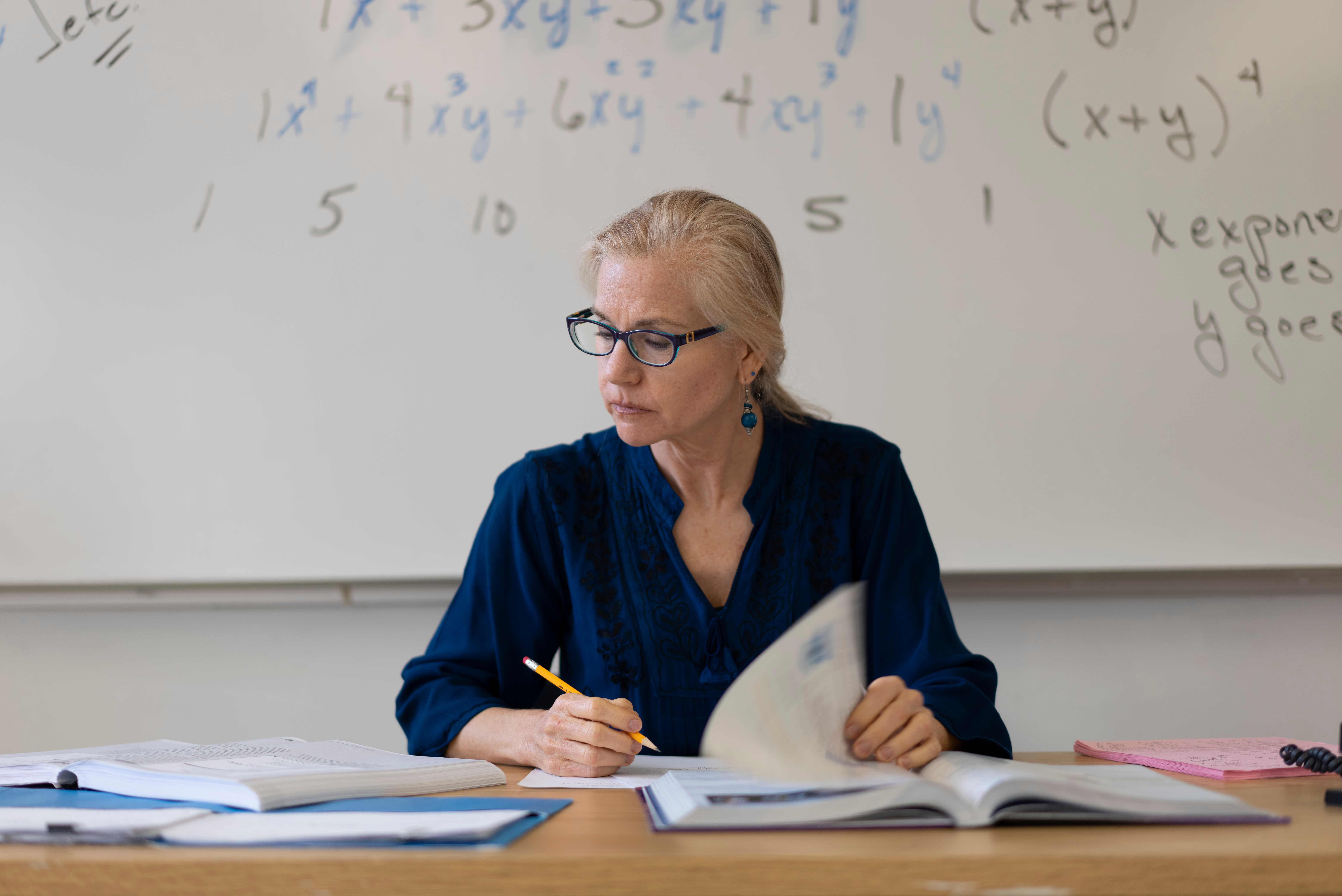 Teacher sitting at a desk and looking at papers