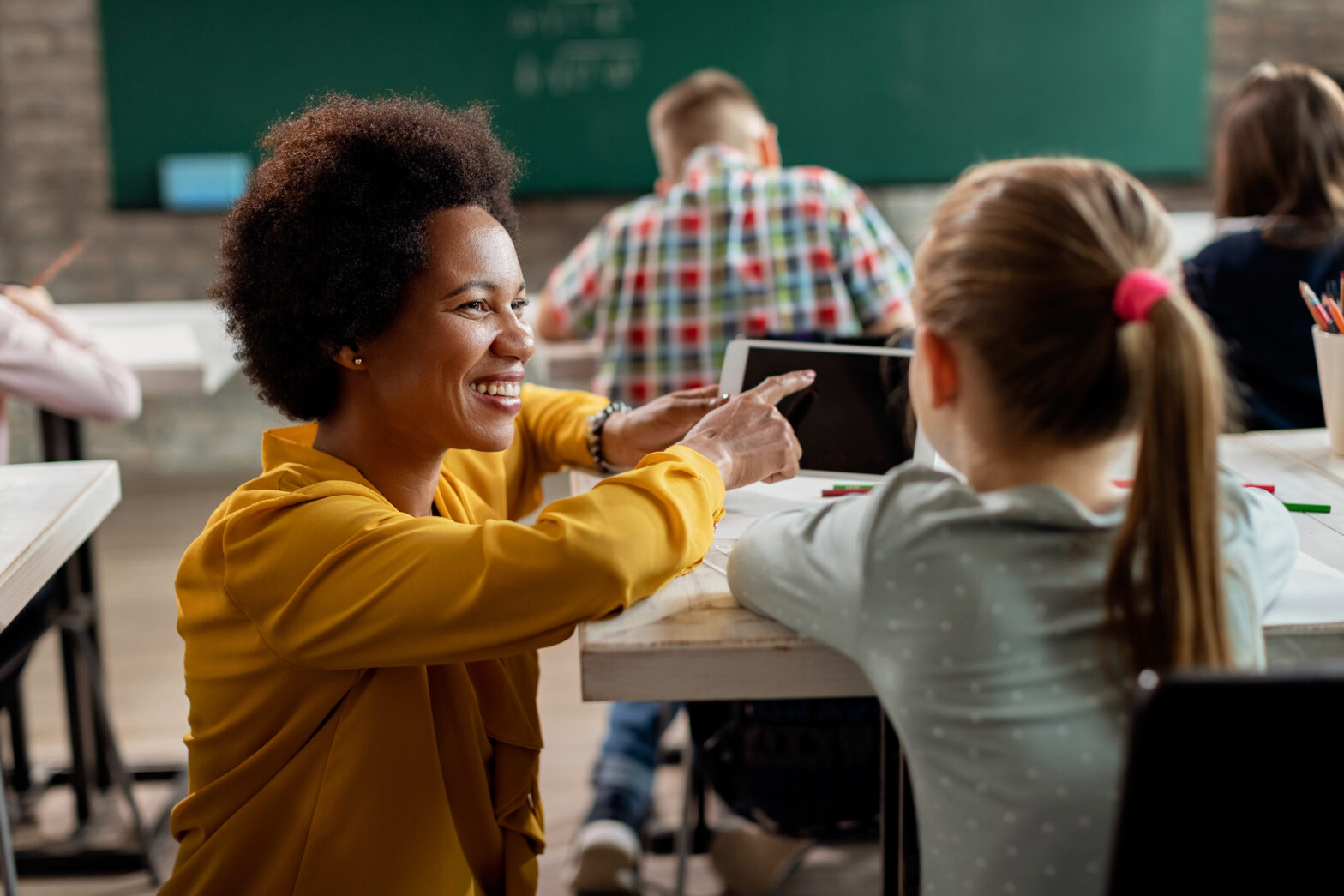Teacher talking to student in classroom